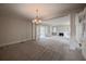 Spacious living room featuring a chandelier, neutral carpet, and decorative pillars and moulding at 1819 Pawnee Trl, Lakeland, FL 33803