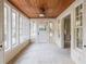 Bright sunroom featuring a wood plank ceiling, neutral carpet, and many windows bringing the outdoors in at 1819 Pawnee Trl, Lakeland, FL 33803