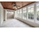 Cozy sunroom with wood-paneled ceiling, ceiling fan, and wall-to-wall windows offering a bright and airy feel at 1819 Pawnee Trl, Lakeland, FL 33803