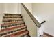 A staircase features decorative tile risers and a wooden handrail for added architectural interest and safety at 1880 N Crystal Lake Dr # 4, Lakeland, FL 33801