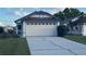 Attached two-car garage featuring decorative windows and a concrete driveway at 2021 Windward Pass, Lakeland, FL 33813