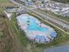 Aerial view of community pool, sunshades, lounge chairs, and manicured landscaping at 211 Emanuelle Dr, Winter Haven, FL 33884