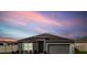 Charming single-story home featuring neutral tones and a two-car garage against a beautiful sky at 211 Emanuelle Dr, Winter Haven, FL 33884