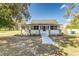 Charming single-story home featuring a cozy front porch with white railings and manicured landscaping at 22 S Cherokee Ave, Fort Meade, FL 33841