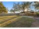 Large backyard with mature trees, grass and a covered patio at 2330 Creek Side Dr, Lakeland, FL 33811