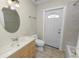 Bright bathroom featuring tile flooring, vanity, toilet, mirror, and a door at 2330 Creek Side Dr, Lakeland, FL 33811