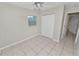 Bedroom featuring tile flooring, ceiling fan, and window and door at 2330 Creek Side Dr, Lakeland, FL 33811