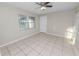 Neutral-toned bedroom features a ceiling fan and light tile flooring at 2330 Creek Side Dr, Lakeland, FL 33811