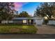 Charming single-story home featuring a metal roof, stone accents, and a well-manicured lawn at 2330 Creek Side Dr, Lakeland, FL 33811