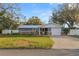 Charming single-story home featuring a metal roof, stone accents, and a well-manicured lawn at 2330 Creek Side Dr, Lakeland, FL 33811