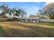 Exterior view shows a ranch-style home with mature trees and a large yard at 2330 Creek Side Dr, Lakeland, FL 33811