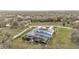 Aerial view of an estate featuring lush landscaping, a screened pool, and a long driveway at 275 Canterwood Ln, Mulberry, FL 33860