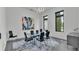 Modern dining room with glass table, black chairs, statement art, and large window with a view at 275 Canterwood Ln, Mulberry, FL 33860