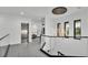 Hallway with staircase featuring glass railings, decorative lighting, and access to the elevator at 275 Canterwood Ln, Mulberry, FL 33860