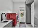 Modern laundry room with a gray accent wall, red appliances, and sink at 275 Canterwood Ln, Mulberry, FL 33860