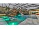 Beautiful indoor pool with rock waterfall, slide, and sun loungers for relaxing at 275 Canterwood Ln, Mulberry, FL 33860