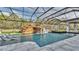 An incredible custom pool with a waterfall, waterslide, and in-water loungers, set within a screened enclosure at 275 Canterwood Ln, Mulberry, FL 33860