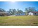 Backyard with large grassy area and home exterior with concrete patio at 2926 Delrose N Dr, Lakeland, FL 33805