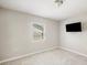 Neutral bedroom features gray tiled floors, one window, and a television at 2926 Delrose N Dr, Lakeland, FL 33805