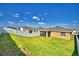 Spacious backyard showcasing the home's exterior, a manicured lawn, and a screened lanai for outdoor enjoyment at 300 Lake Smart Cir, Winter Haven, FL 33881