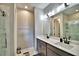 Bathroom featuring double sinks, a large mirror, and a walk-in shower at 300 Lake Smart Cir, Winter Haven, FL 33881