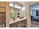 Bathroom featuring double sinks, a large mirror, walk-in shower, and bedroom view at 300 Lake Smart Cir, Winter Haven, FL 33881