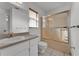 Bathroom featuring a vanity, commode, and enclosed shower-tub combination with sliding glass doors at 3102 Pebble Bend Dr, Lakeland, FL 33810