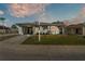 Inviting single-story home with attached carport, lush lawn, and colorful sunset sky provides a picturesque curb appeal at 3102 Pebble Bend Dr, Lakeland, FL 33810