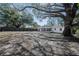 Large backyard with mature trees and covered patio, providing ample outdoor space at 320 E Daughtery Rd, Lakeland, FL 33809