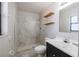 Bathroom featuring tiled walk-in shower, floating shelves, and modern vanity at 320 E Daughtery Rd, Lakeland, FL 33809