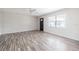 Bright living room with light wood laminate flooring, ceiling fan, and large window at 320 E Daughtery Rd, Lakeland, FL 33809