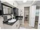 Updated bathroom featuring a sleek vanity with white cabinets, black countertops, and a walk-in closet at 327 Corona Del Mar St, Lakeland, FL 33809