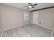 This cozy bedroom features wood-look flooring, a ceiling fan and an accent border around the ceiling at 327 Corona Del Mar St, Lakeland, FL 33809