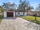 Quaint single-story home with a large driveway and minimalist landscaping at 327 Corona Del Mar St, Lakeland, FL 33809