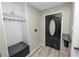 Functional foyer with coat hooks, seating, and a stylish front door at 327 Corona Del Mar St, Lakeland, FL 33809