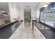 Galley kitchen with white cabinets, dark countertops, and stainless steel sink at 327 Corona Del Mar St, Lakeland, FL 33809