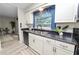 Well-lit kitchen featuring stainless steel sink, black countertops and white cabinets at 327 Corona Del Mar St, Lakeland, FL 33809