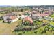 Aerial view of the home showcasing a well-manicured lawn, mature trees, and a red tile roof at 3978 Viamonte Ln, Lakeland, FL 33810