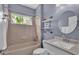 Bathroom featuring tiled walls, a window with natural light, a vanity with a sink, and neutral fixtures at 3978 Viamonte Ln, Lakeland, FL 33810