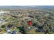 Wide aerial shot of property with trees and nearby commercial area in the distance at 4075 Davis Rd, Mulberry, FL 33860