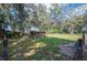 Large backyard with a pet house and mature trees, partially fenced and well-maintained at 4075 Davis Rd, Mulberry, FL 33860