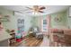 Bright bedroom with green walls, a cozy chair with ottoman, and a crib by the window at 4075 Davis Rd, Mulberry, FL 33860