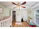 Bright bedroom with hardwood floor, a crib, dresser, and natural light from the window at 4075 Davis Rd, Mulberry, FL 33860