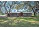 Charming single-story home with rustic wood siding, metal roof, and mature trees in a large front yard at 4075 Davis Rd, Mulberry, FL 33860