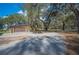 A detached garage and a wide driveway with ample parking space surrounded by mature trees at 4075 Davis Rd, Mulberry, FL 33860