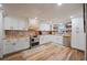 Well-lit kitchen with white cabinets, a brick backsplash, butcher block countertops, and stainless steel appliances at 4075 Davis Rd, Mulberry, FL 33860