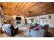 Cozy living room featuring a stone fireplace, wood ceiling, and comfortable furnishings at 4075 Davis Rd, Mulberry, FL 33860