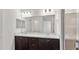 Bright bathroom featuring double vanities, a large mirror, and a glass-enclosed shower at 4522 Rapallo Ave, Winter Haven, FL 33884