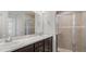 Well-lit bathroom featuring a double vanity with marble countertop and a glass-enclosed tiled shower at 4522 Rapallo Ave, Winter Haven, FL 33884
