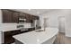 Modern kitchen featuring dark wood cabinets, stainless steel appliances, and a large quartz-topped island at 4522 Rapallo Ave, Winter Haven, FL 33884